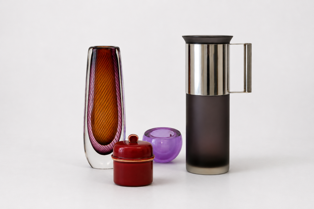 Composizione di vaso in vetro di Murano, brocca di design, portacandela in vetro viola e scatola laccata.